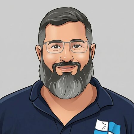 Homme souriant avec barbe et lunettes, portant un polo avec logo association numérique.